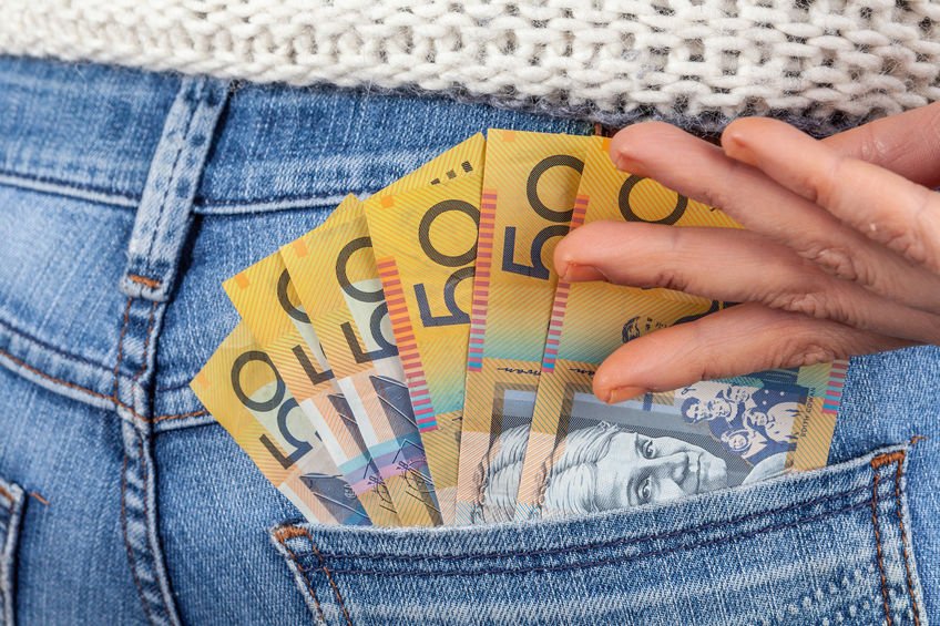 $50 notes being put into back pocket of jeans